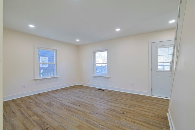 spare room featuring light hardwood / wood-style flooring and a healthy amount of sunlight