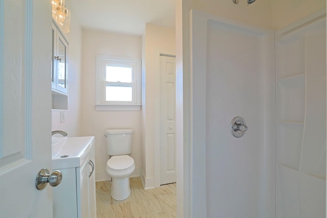 bathroom featuring vanity, toilet, and walk in shower