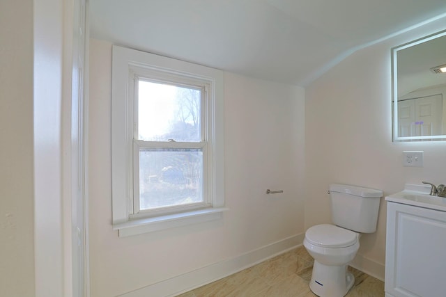 bathroom featuring vanity, toilet, and lofted ceiling