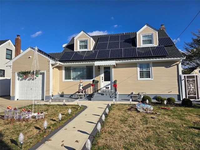 cape cod house featuring a front lawn, a garage, and solar panels