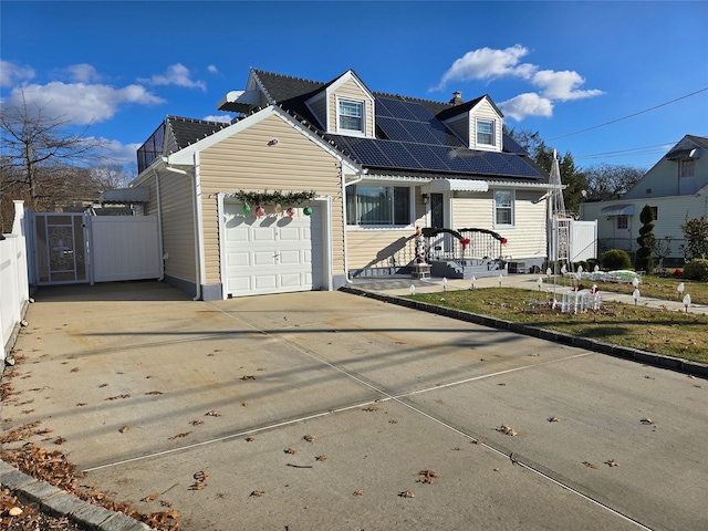 cape cod-style house with solar panels and a garage