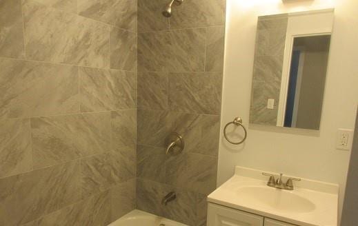 bathroom featuring vanity and tiled shower / bath combo