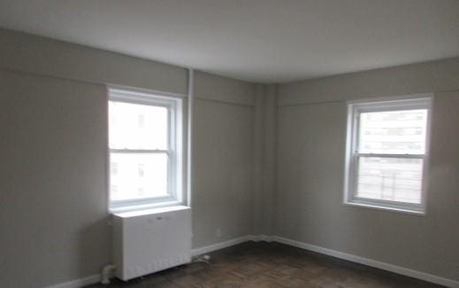 unfurnished room featuring dark parquet floors