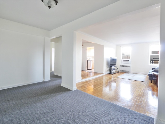 unfurnished living room featuring hardwood / wood-style flooring and radiator