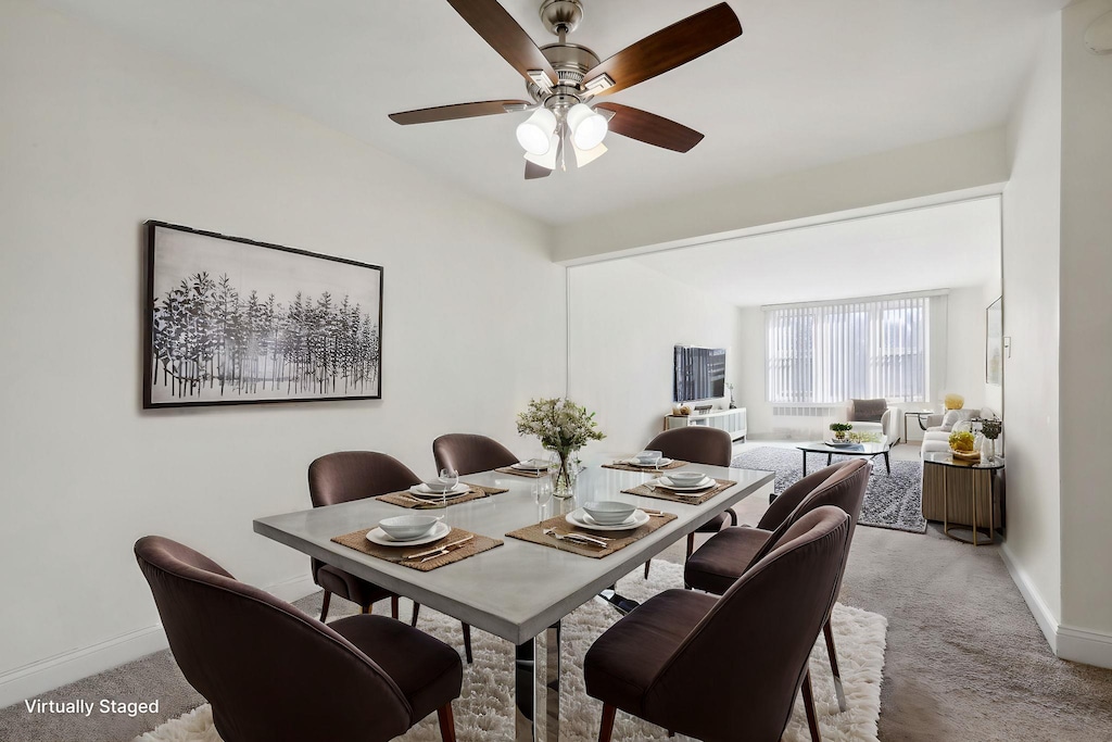 carpeted dining area with ceiling fan