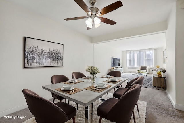 carpeted dining area with ceiling fan