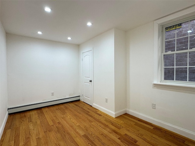 unfurnished room featuring light hardwood / wood-style flooring and a baseboard radiator