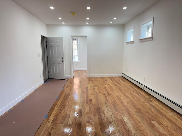 spare room featuring light hardwood / wood-style floors and a baseboard heating unit