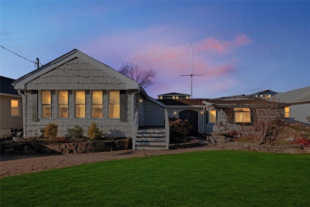 back house at dusk with a yard