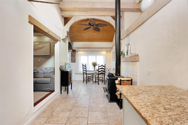 hall featuring light tile patterned floors and lofted ceiling with beams