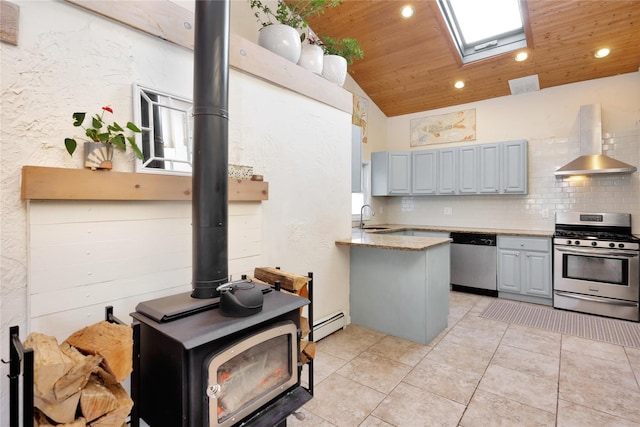 kitchen with gray cabinets, sink, stainless steel appliances, and wall chimney range hood