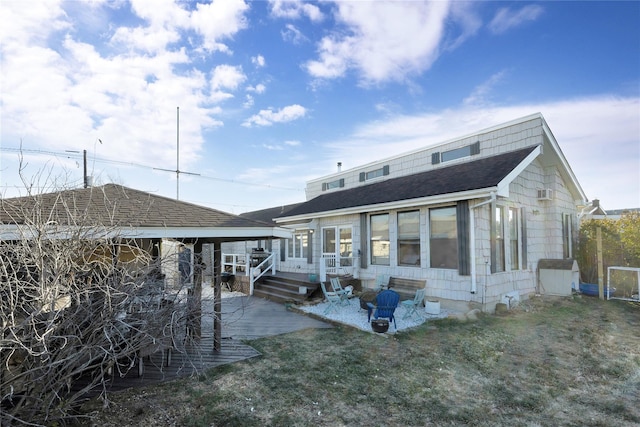 back of house with a lawn, a wooden deck, and a patio area