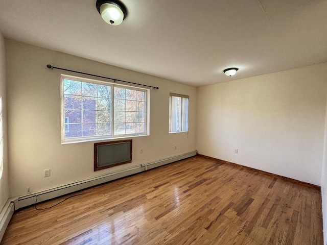 unfurnished room featuring a baseboard radiator and light wood-type flooring