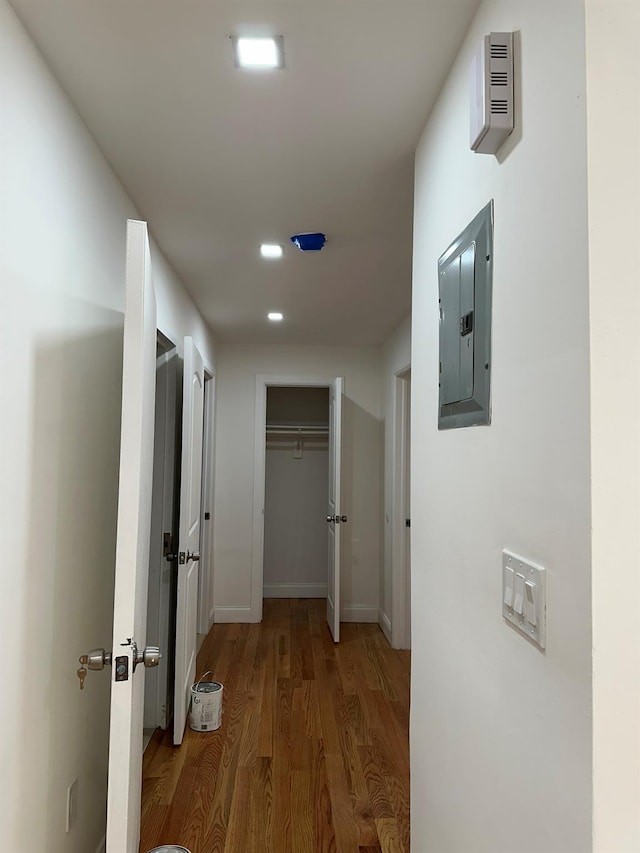 hallway with wood-type flooring and electric panel