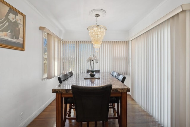 dining room featuring a chandelier, crown molding, and dark wood-type flooring