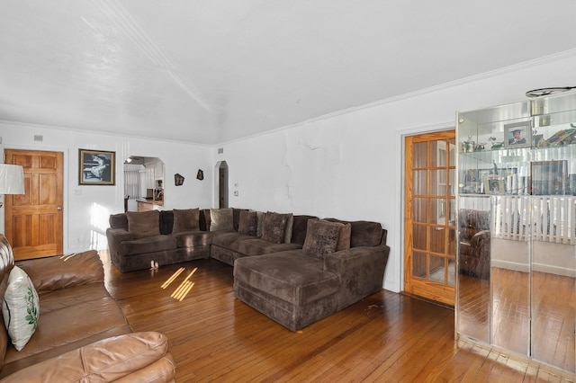 living room with wood-type flooring, plenty of natural light, and ornamental molding