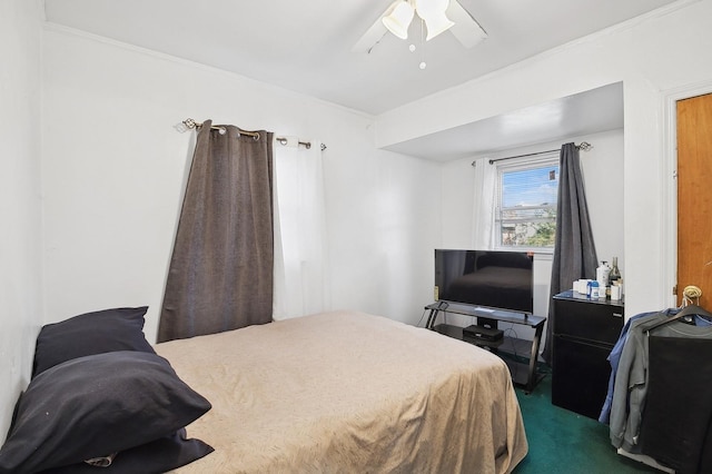 carpeted bedroom featuring ceiling fan and crown molding