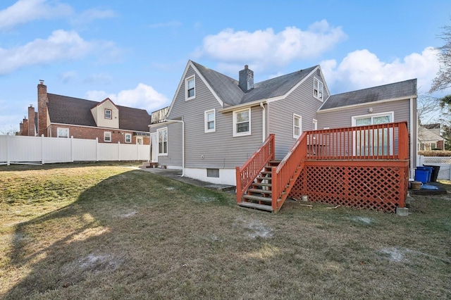 rear view of property featuring a yard and a deck