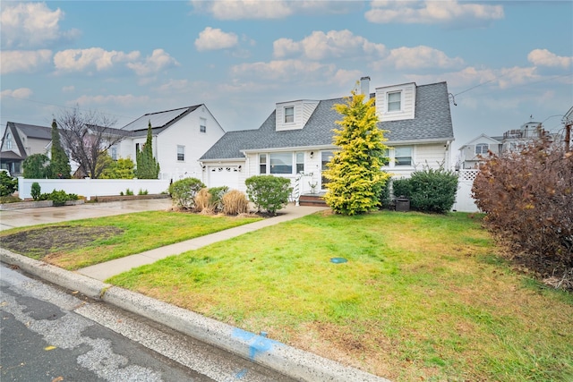 cape cod home with a garage and a front yard