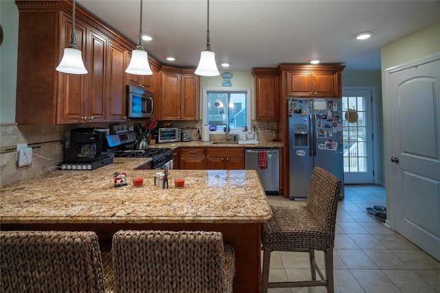 kitchen with a kitchen bar, sink, appliances with stainless steel finishes, and tasteful backsplash