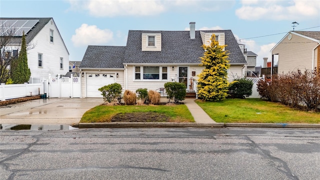 new england style home with a garage and a front lawn