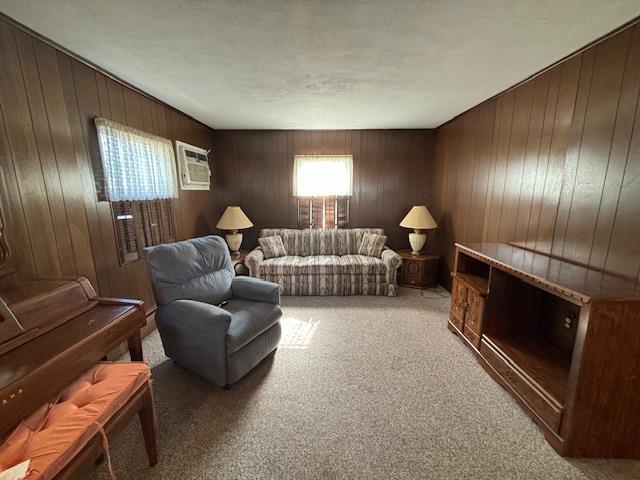 sitting room featuring an AC wall unit, wood walls, and carpet