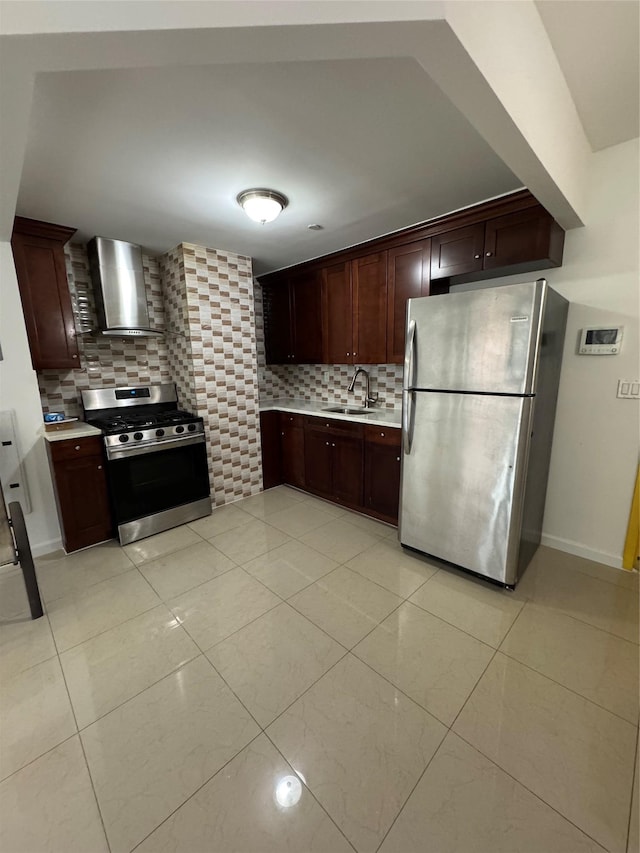 kitchen with tasteful backsplash, stainless steel appliances, sink, wall chimney range hood, and light tile patterned floors