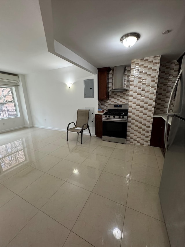 kitchen with appliances with stainless steel finishes, wall chimney exhaust hood, dark brown cabinets, light tile patterned floors, and electric panel