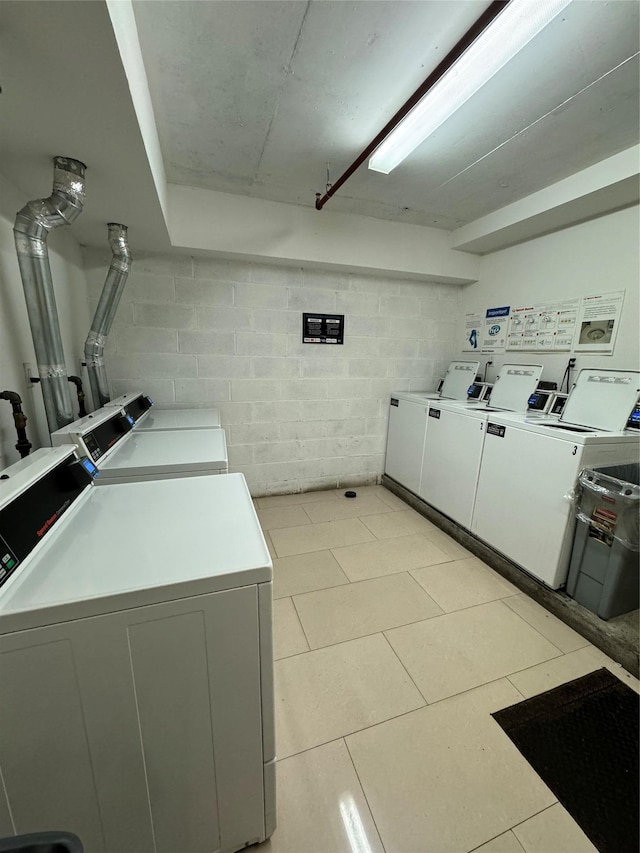 washroom with independent washer and dryer and light tile patterned floors