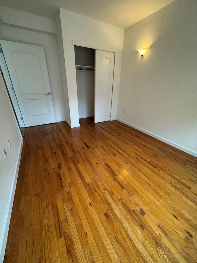 unfurnished bedroom with light hardwood / wood-style floors and a closet