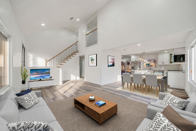 living room featuring a high ceiling and light hardwood / wood-style flooring