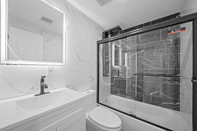 full bathroom featuring enclosed tub / shower combo, toilet, decorative backsplash, vanity, and tile walls