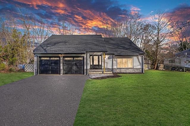 view of front of house with a garage and a lawn