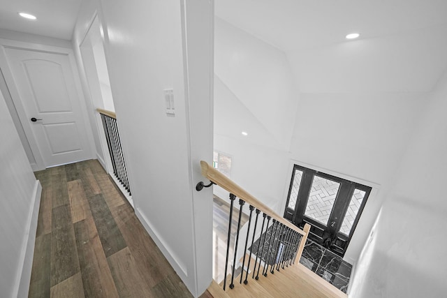 hallway with a towering ceiling and dark hardwood / wood-style floors