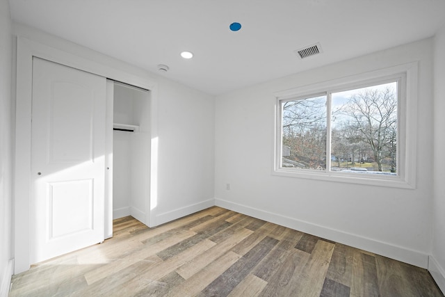 unfurnished bedroom with light hardwood / wood-style floors and a closet