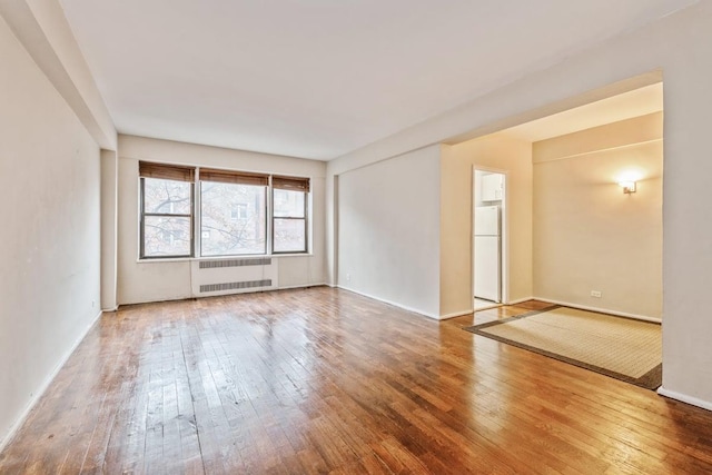 spare room featuring hardwood / wood-style flooring and radiator