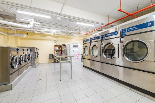 laundry area with washer and clothes dryer and light tile patterned floors