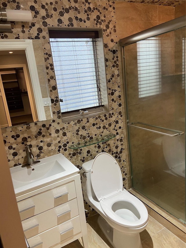 bathroom featuring vanity, toilet, an enclosed shower, and tile walls