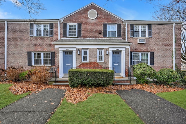 view of front facade with brick siding and a front lawn