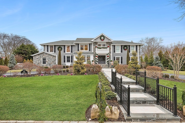 view of front of house with a balcony and a front lawn