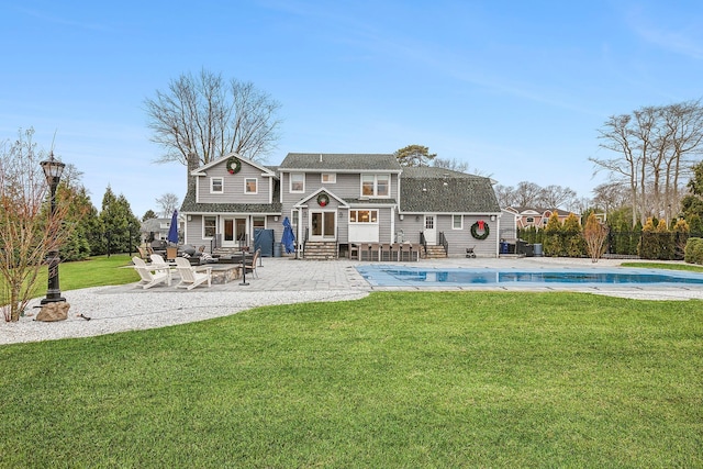 rear view of house featuring a yard, a covered pool, and a patio area