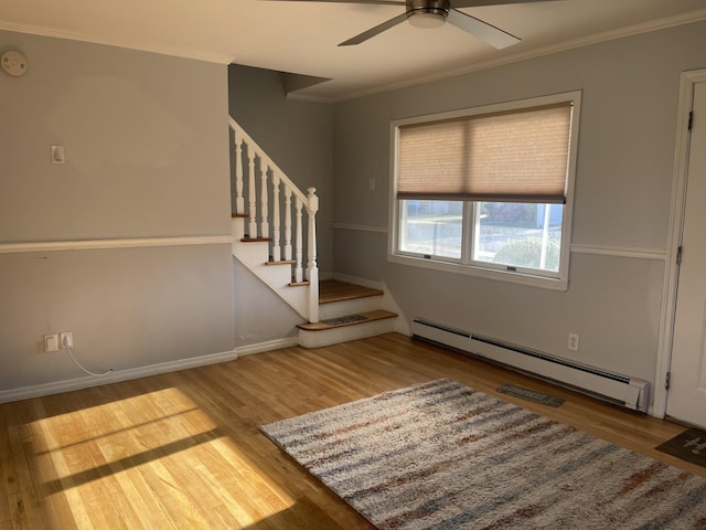 empty room with ceiling fan, crown molding, wood-type flooring, and baseboard heating