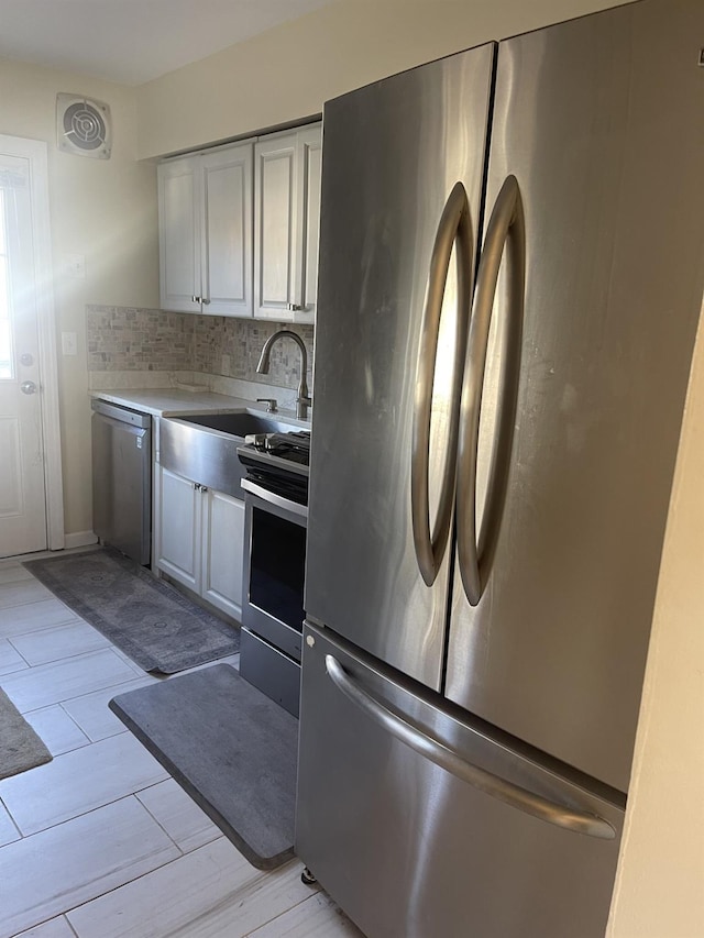 kitchen featuring tasteful backsplash, sink, stainless steel appliances, and light wood-type flooring