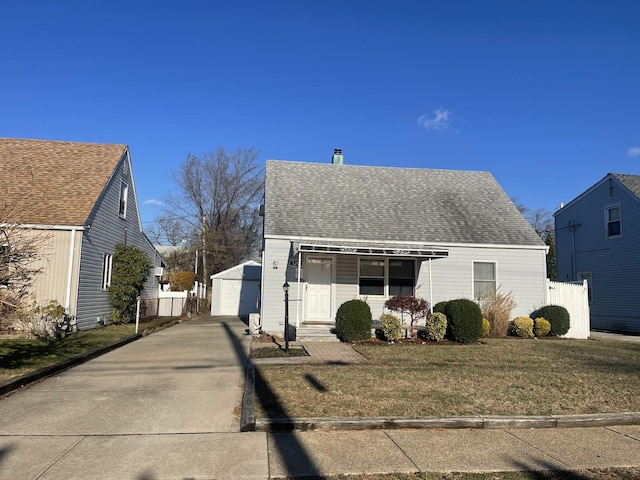 view of front facade featuring a porch, a front lawn, an outdoor structure, and a garage