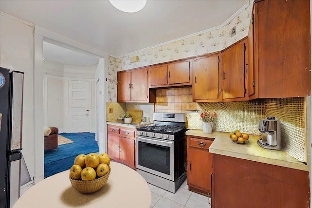 kitchen with appliances with stainless steel finishes, tasteful backsplash, and light tile patterned floors