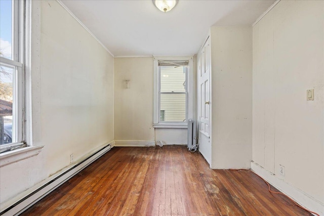 spare room featuring radiator, crown molding, dark hardwood / wood-style floors, and a baseboard heating unit