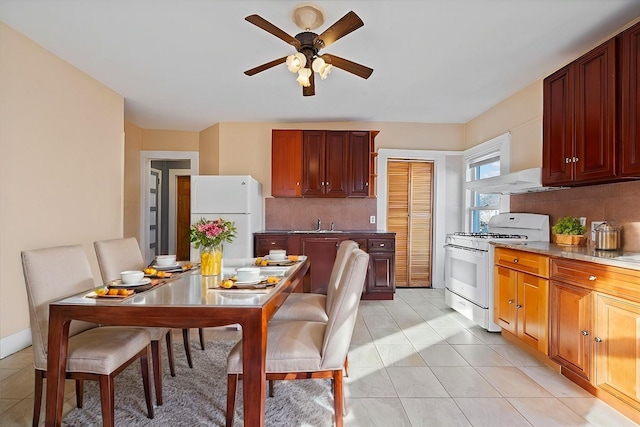 kitchen with white appliances, ceiling fan, light stone countertops, light tile patterned floors, and tasteful backsplash