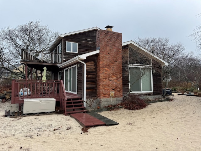 view of side of home with a balcony and a wooden deck