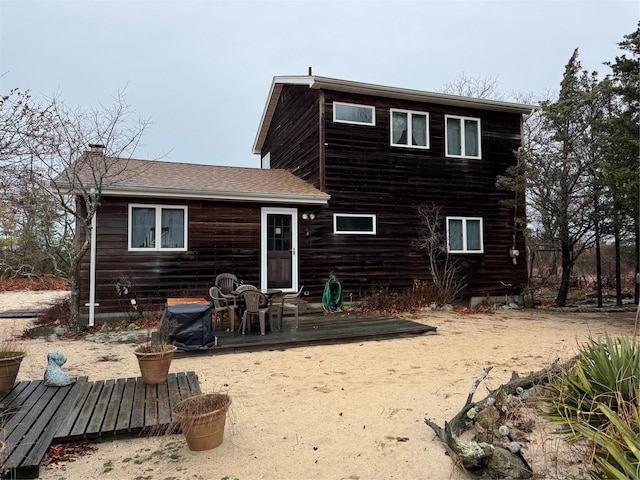 rear view of house featuring a wooden deck