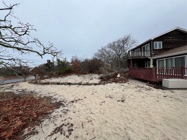 view of yard with a balcony and a deck